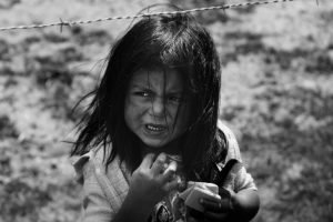 ecuador mission trip girl holding hair comb behind barbed wire